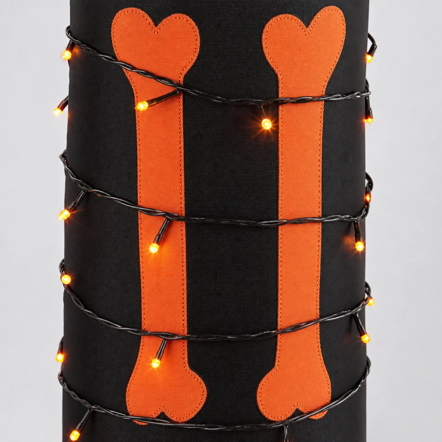 Macro of the 115-light string wound around one leg, each bulb a small point of orange